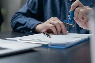 Person stamping a document being signed