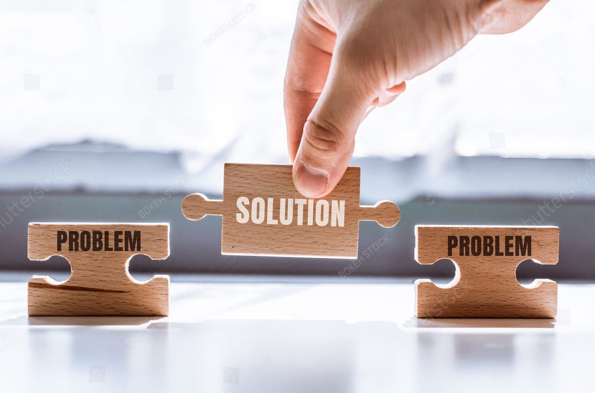 Hand placing a wooden puzzle piece labeled Solution between two labeled Problem